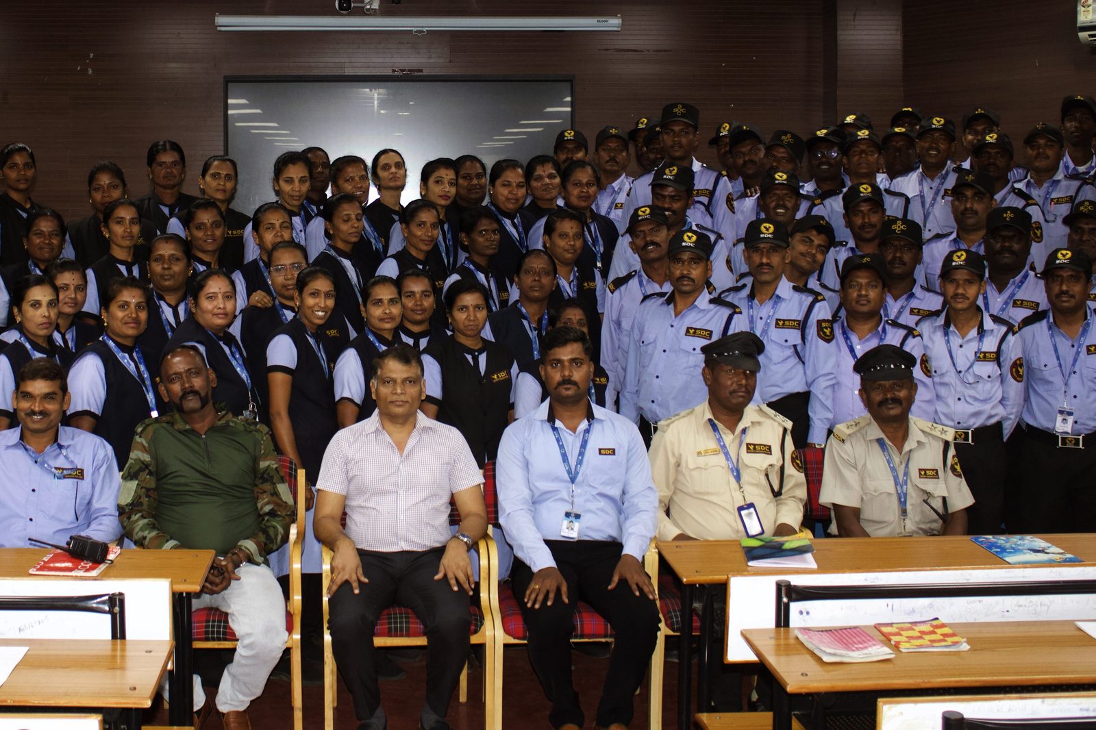 A full SDC training batch of guards and lady guards in a lecture hall, with SDC’s leadership seated in front