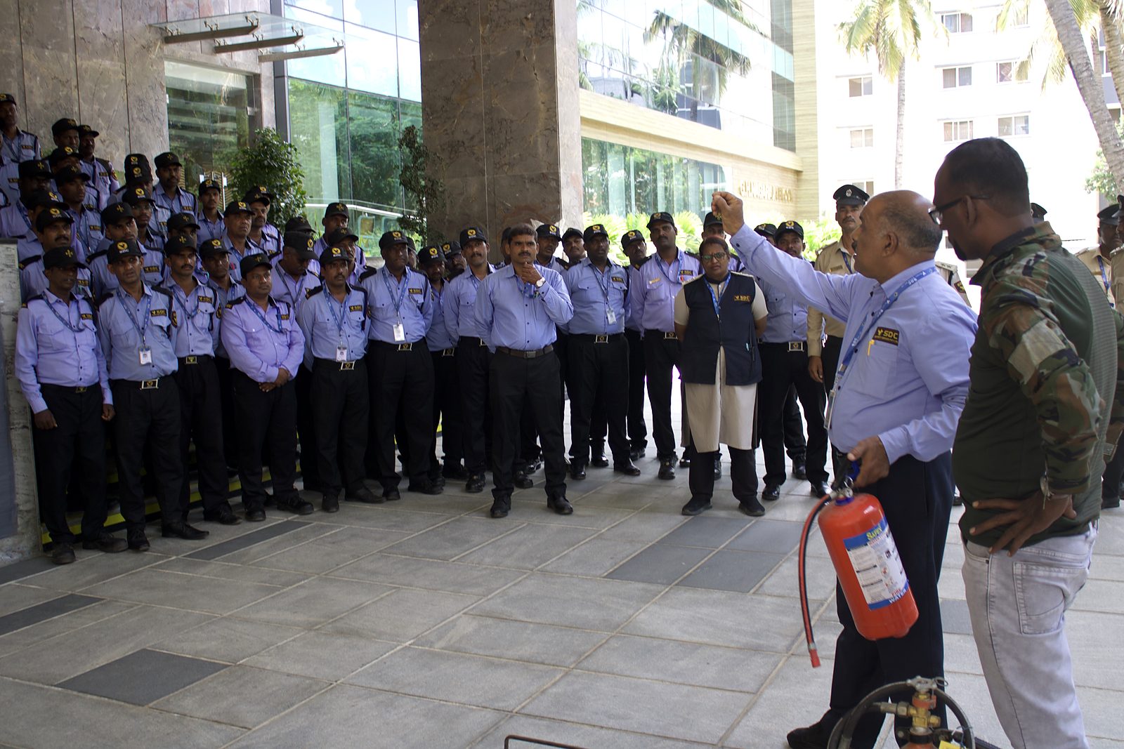 An instructor holding up a fire extinguisher in front of SDC guards and lady guards