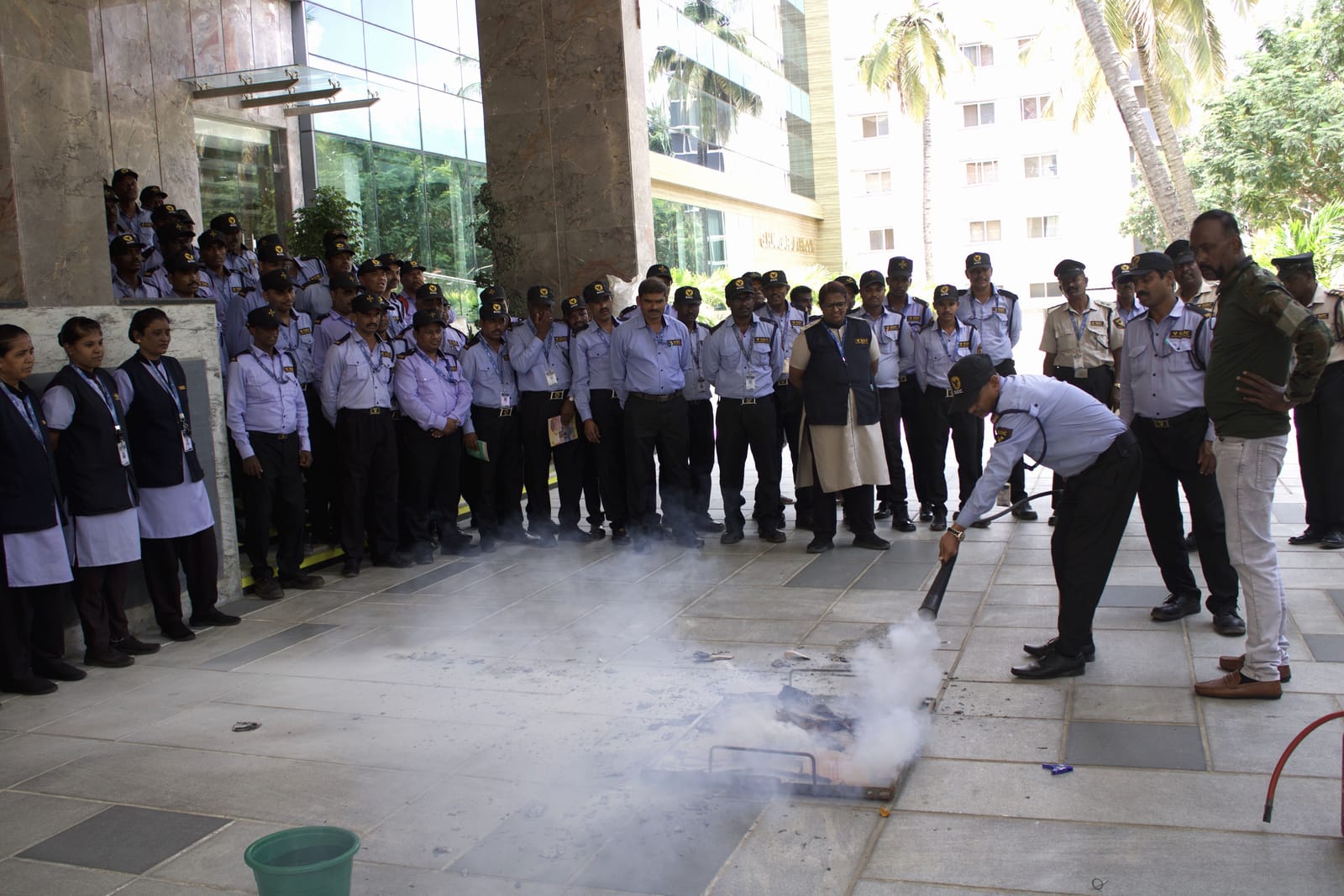 An SDC guard putting out a training fire with an extinguisher while the batch watches